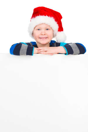 Smiling little boy looking at camera. Standing with white poster isolated on whiteの写真素材