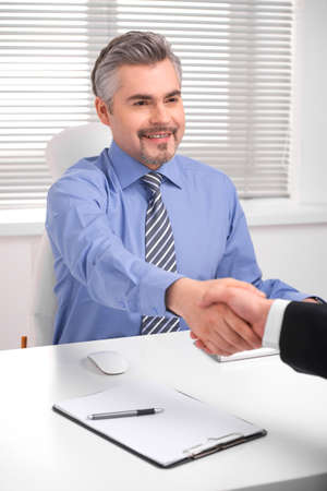 Smiling adult business man shaking hands. Close up of hand shake during successful negotiationsの写真素材