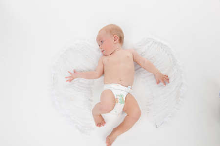 Cute little baby flying with angel wings. Looking away and isolated over white backgroundの写真素材