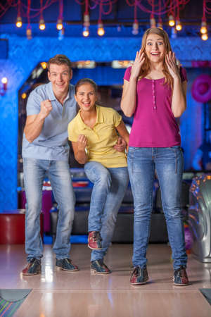 Friends bowling together. Group of four friends in a bowling alley having funの写真素材