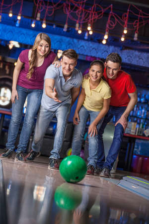 Group of friends bowling. Happy group of friends having fun bowlingの写真素材