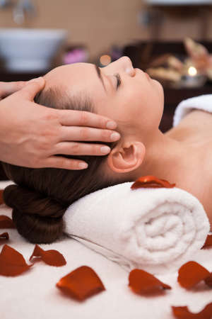 girl is given head massage. girl laying on towel and enjoying の写真素材