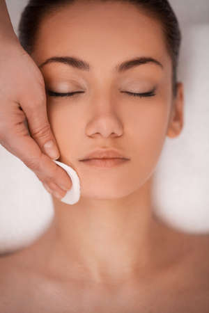 Close-up of gentle make up removal  beautiful young adult woman and cotton padの写真素材