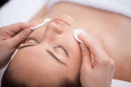 Close-up of make up removal  beautiful young adult woman and cotton padsの写真素材