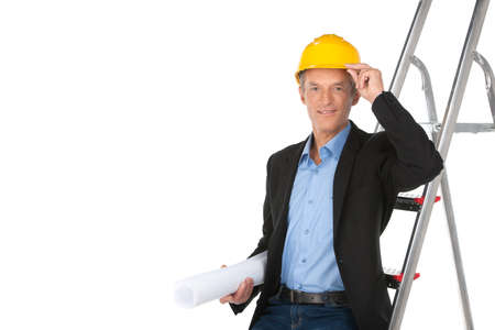 professional architect standing and holding plan. confident foreman working and touching helmetの写真素材
