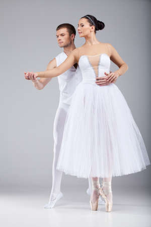 attractive dancing couple holding hands. beautiful ballet dancers tiptoe and lookingの写真素材