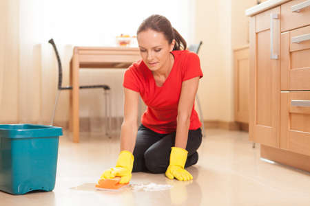 young girl washing floor in kitchen. beautiful housewife doing cleaning and washingの写真素材