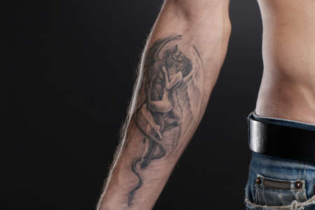 tattooed young man showing hand. attractive man wearing blue jeans
