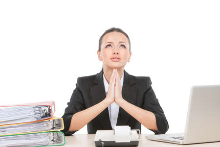 beautiful young worker praying and working. attractive business woman sitting at deskの写真素材