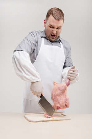man cutting chicken wing and watching. professional cook holding knife and pullingの写真素材