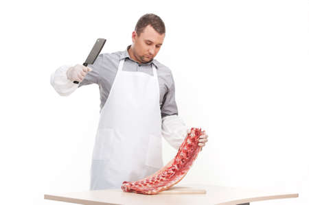 professional butcher cutting meat on table. man holding sharp knife and standingの写真素材