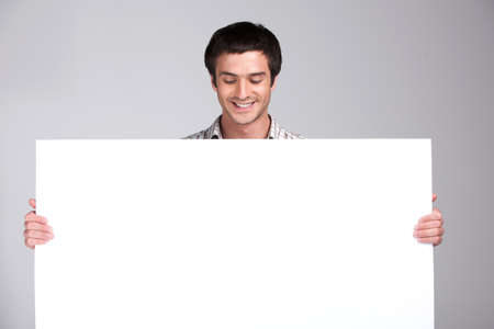 close up of man showing white board. guy showing empty space white placard の写真素材