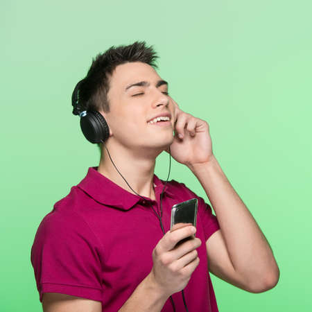 young handsome man listening music. attractive young student enjoying music の写真素材
