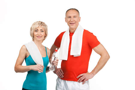 pretty man and woman standing in gym. aged lady holding water and smilingの写真素材