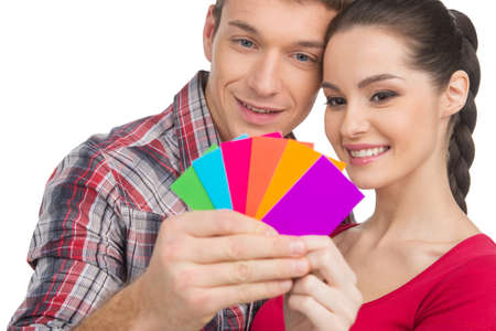 beautiful couple selecting color and smiling. man and woman looking at colorful cardsの写真素材