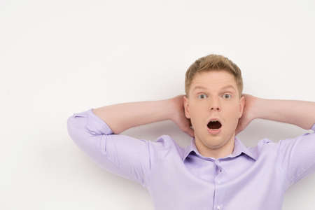 Relaxed young man on white background. guy putting hands behind headの写真素材