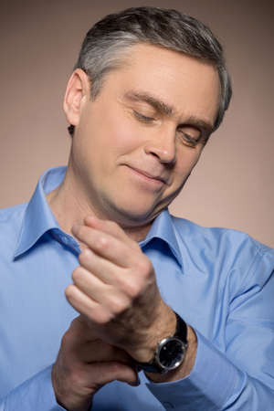closeup portrait of man wearing watches. man with watches isolated on brown backgroundの写真素材