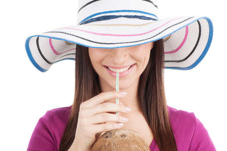 attractive girl drinking orange juice. closeup of brunette wearing hat and smilingの写真素材