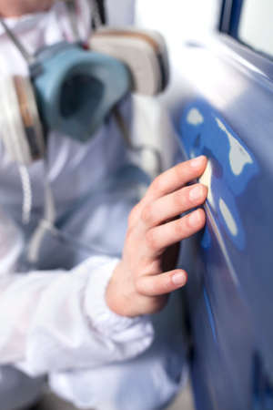 young man touching car door. man wearing respirator and sitting in shopの写真素材