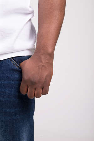 black male standing still horizontally. hands in pockets on white backgroundの写真素材