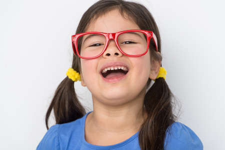 nice little girl wearing glasses. small girl smiling and laughing out loudの写真素材
