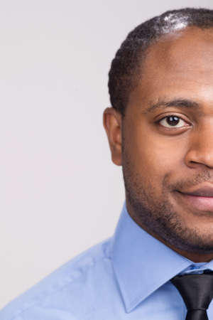 black handsome man face close-up. serious man looking straight smilingの写真素材