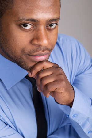 good looking black man thinking. handsome man folded hands and thinkingの写真素材