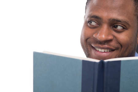 handsome black man looking away. Attractive and smiling male reading bookの写真素材