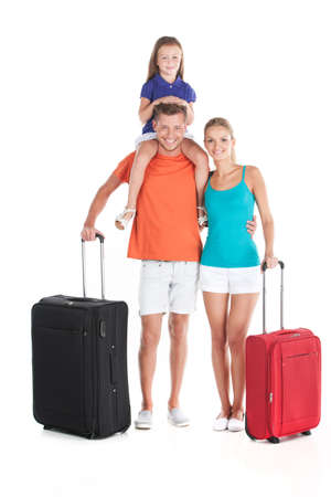 happy family walking with luggage on white background. man carrying girl and hugging womanの写真素材