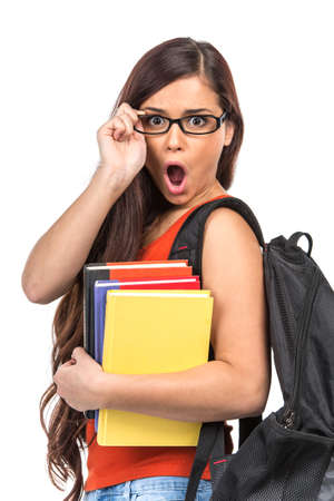 surprised young student holding glasses. amazed young girl holding booksの写真素材