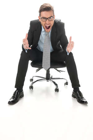 Young businessman shouting and sitting on a chair. closeup of guy sitting in tie and glasses on white backgroundの写真素材