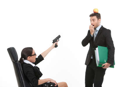 quarrel between man and woman over white background. woman sitting on chair and pointing at man with gunの写真素材