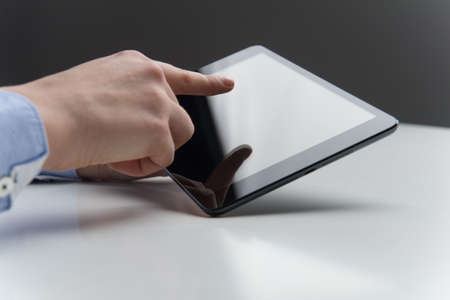 woman fingers over modern tablet with blank screen. Touch screen tablet computer with hand isolated