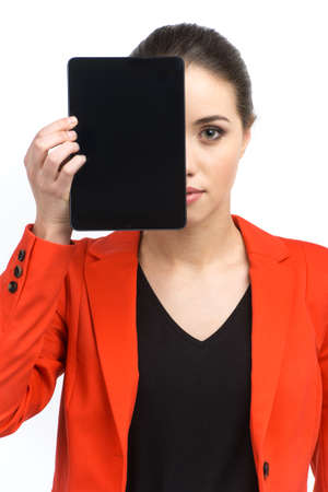 Woman holding up blank tablet computer. Girl obscuring half of her face with screenの写真素材