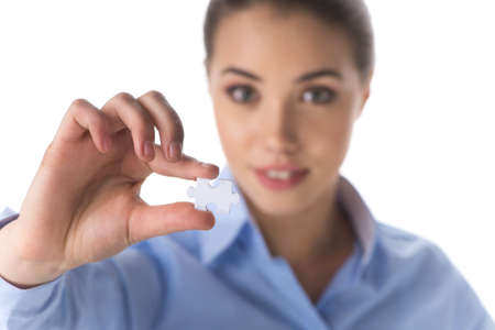 business woman holding piece of puzzle. focus on white puzzle in businesswoman's hand の写真素材