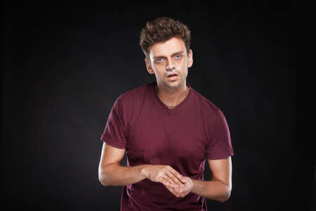 Young guy sniffing cocaine on black background. Drug addicted cocaine man intoxicated with cokeの写真素材