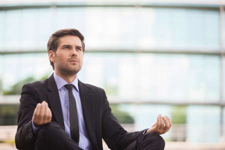 Young adult man sitting on floor. handsome guy in Lotus yoga pose. の写真素材