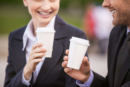 Business people drinking coffee outside. Business partners closeup while on stairs の写真素材