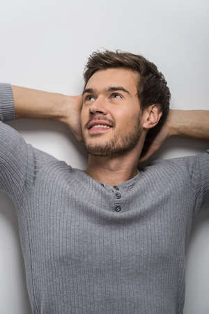 Happy Man Isolated On White Background. guy holding hands behind head and looking upの写真素材
