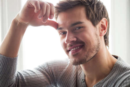 closeup portrait of attractive young man. Portrait of happy young man holding head