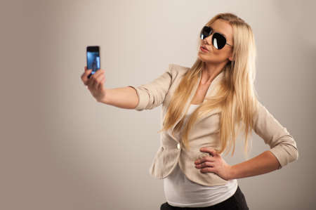 Happy young girl taking pictures of herself. young and attractive teenage girl with mobile phoneの写真素材