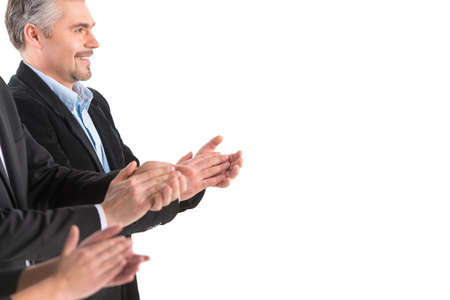 Photo of business people applauding at white background. Photo of partners applauding at meeting and...