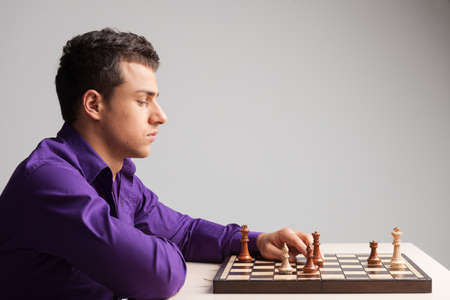 Man playing chess on white background. side view up of young man moving pieceの写真素材