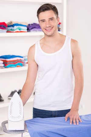 Man ironing shirt before leaving for work. man ironing on ironing board his pantsの写真素材