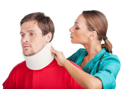 Young Man Wearing Cervical Collar. doctor putting neck brace on white backgroundの写真素材