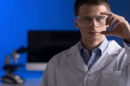 research and science doctor wearing glasses. man in bright laboratory representing chemistry education and medicine conceptの写真素材