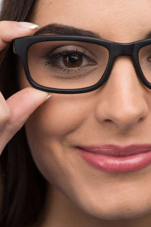 black glasses woman closeup portrait. Woman wearing glasses holding frame in close-up.