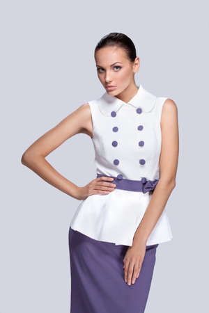 Young sexy brunette in purple and white dress. Fashion studio shot of beautiful woman with makeup and hairstyleの写真素材