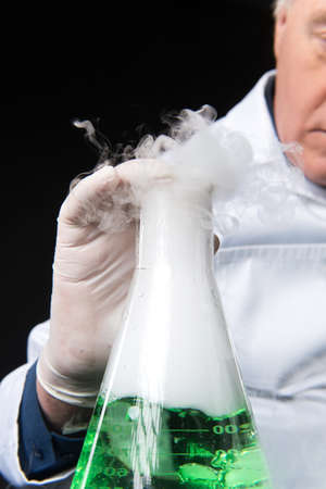 professional clinician studies in laboratory using flask. closeup on man sitting on black background...