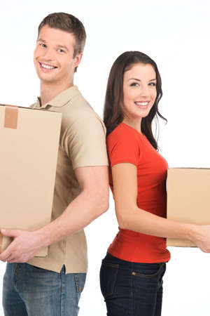 Beautiful young couple standing close to each other. man and woman smiling at camera while holding cardboard boxesの写真素材